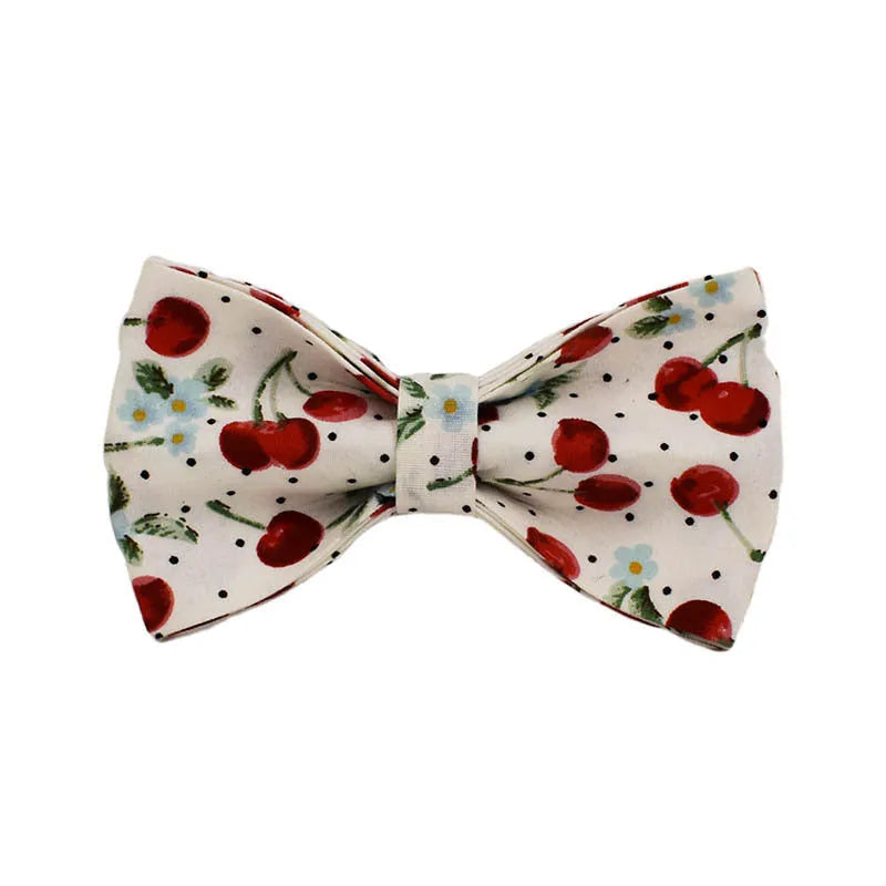 Red cherry print dog collar and leash set with light gold buckle, matching bow, vest, and poop bag.