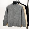 Man wearing a thick grey stand collar knitted cardigan with a zipper front.