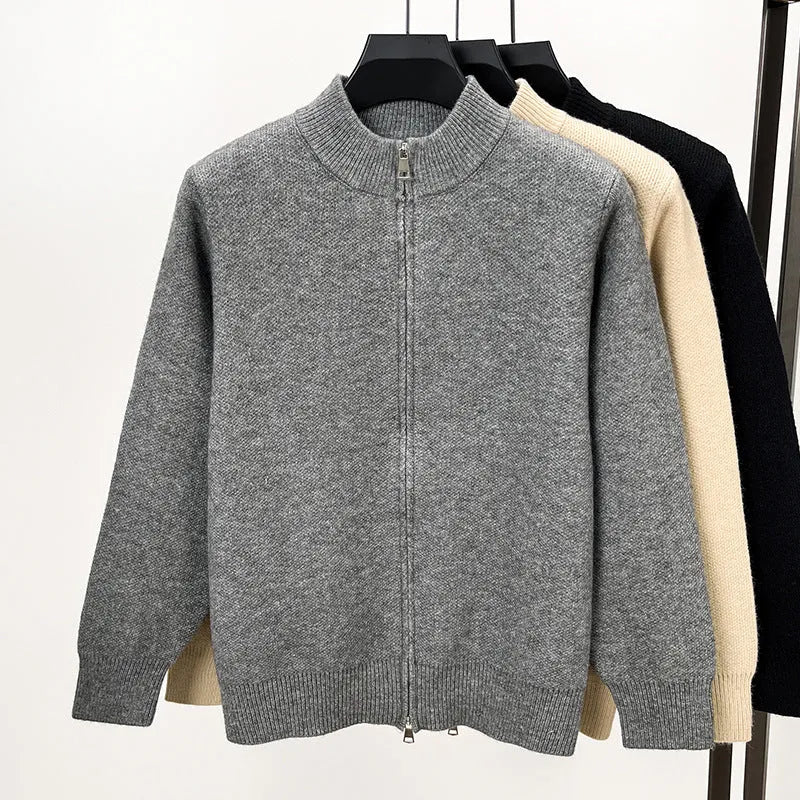 Man wearing a thick grey stand collar knitted cardigan with a zipper front.