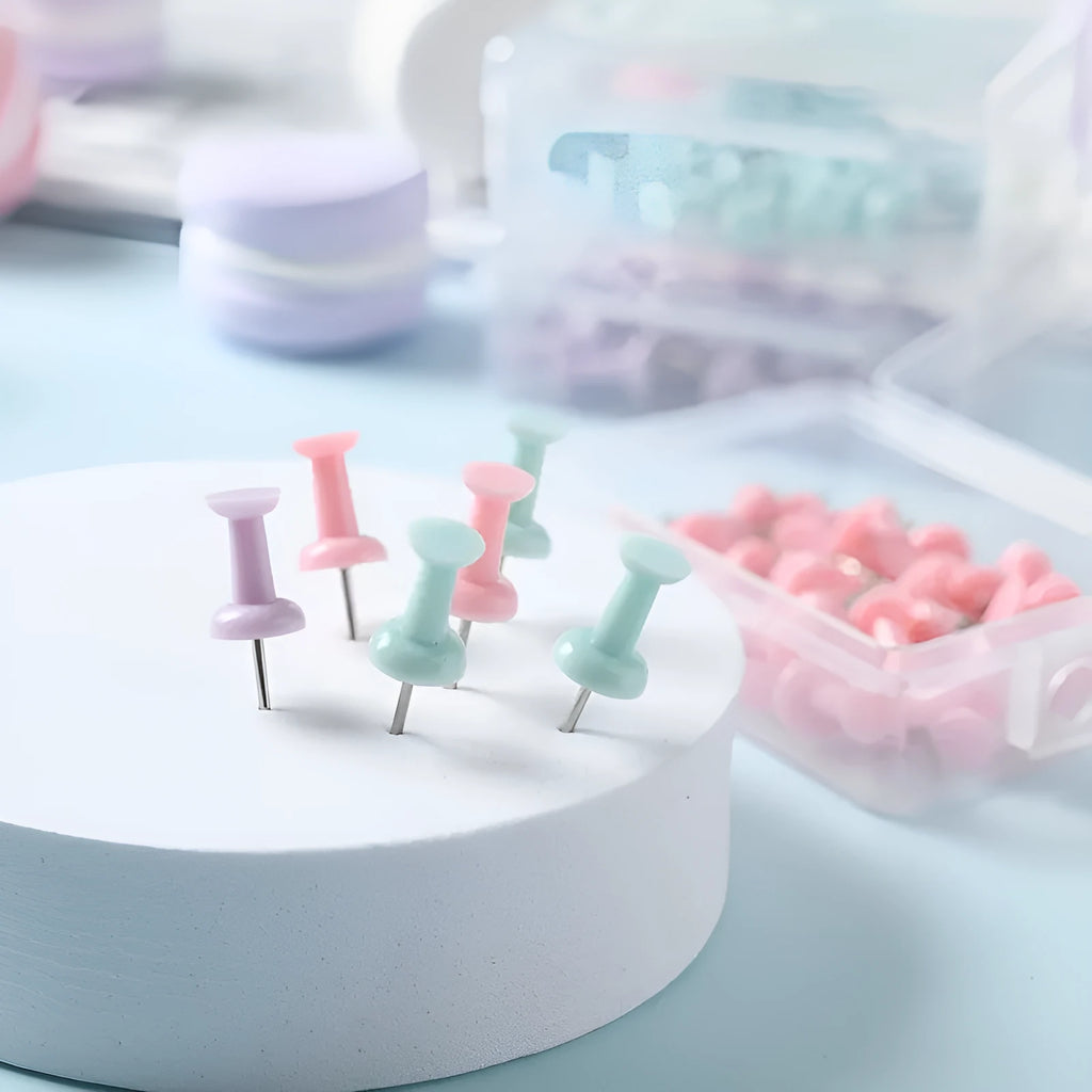 Plastic push pins in cherry blossom pink, mint green, and lavender colours, showing both large and small sizes on a white surface