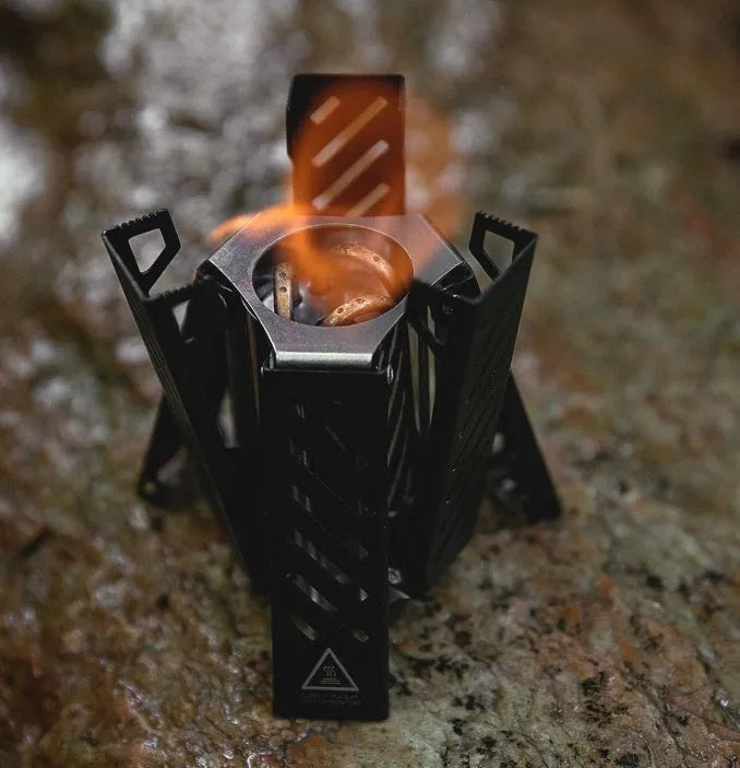 Hexagon-shaped foldable alcohol camping stove in black or silver measuring 9.5x8.5x15cm