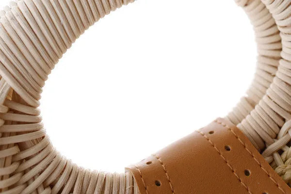 Women's round woven paper rope handbag in beige with hard shell, cover closure, and hard handle