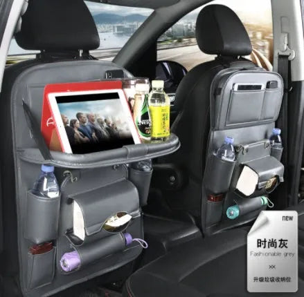 Black PU leather car seat back storage organiser with multiple pockets, attached behind a car headrest.