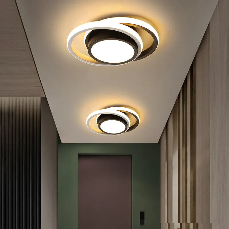 Modern round aluminium ceiling light with integrated LEDs, shown illuminating an entrance hall.