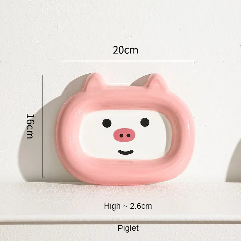 Glazed ceramic pet food bowl with animal design and non-slip rubber base ring.