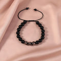 Adjustable luminous glass bead bracelet in geometric shapes on wrist showing elastic cord threading