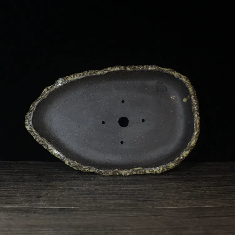 Handmade purple clay flower pot showing natural ceramic texture and floor-standing design