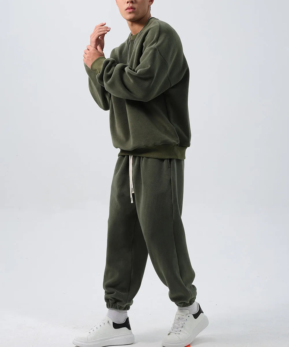 Man wearing a loose black polar fleece winter sports suit with crew neck coat and trousers
