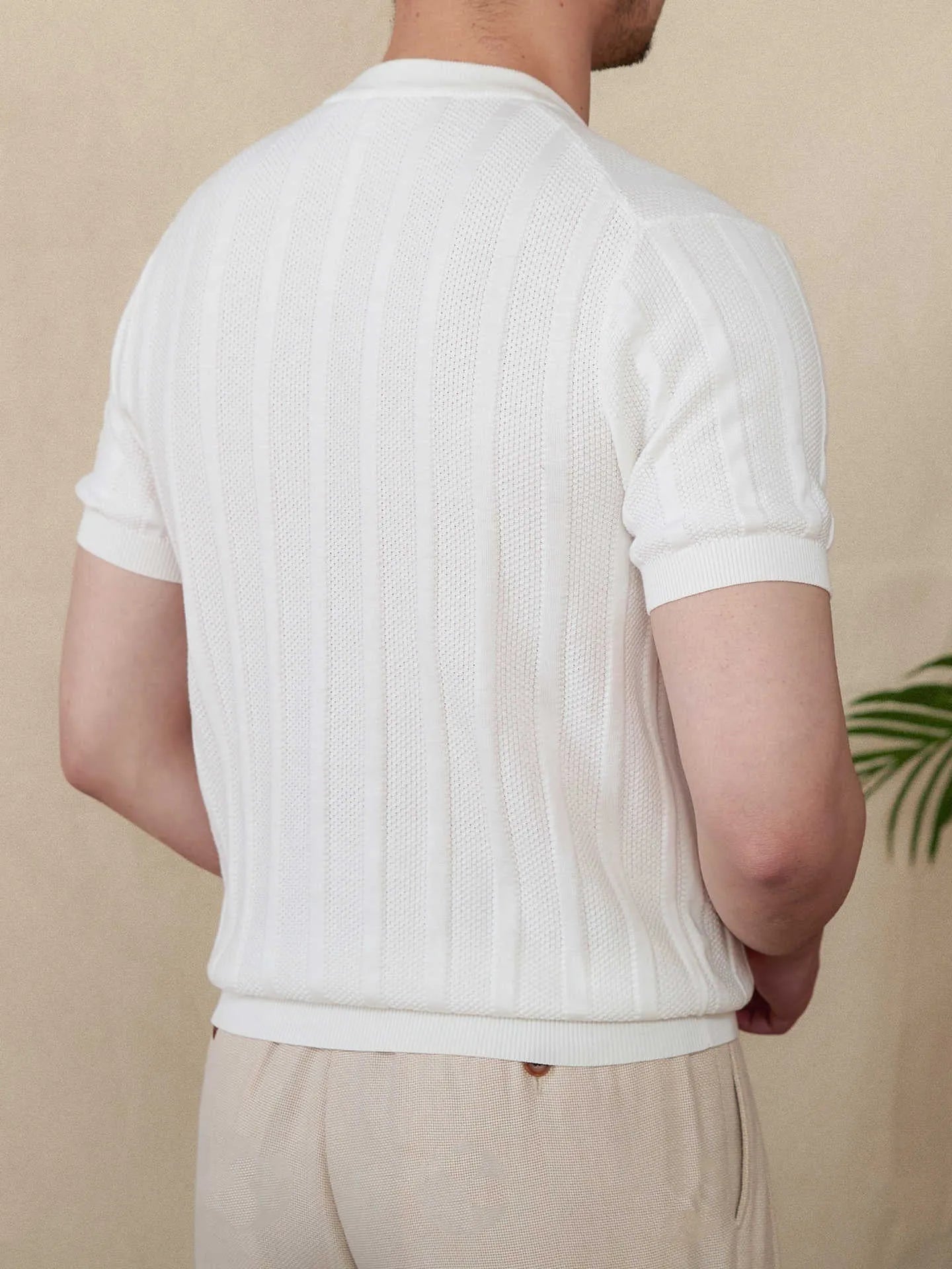 Men's creamy-white knitted short-sleeve t-shirt with a Henry collar and sunken stripe texture.