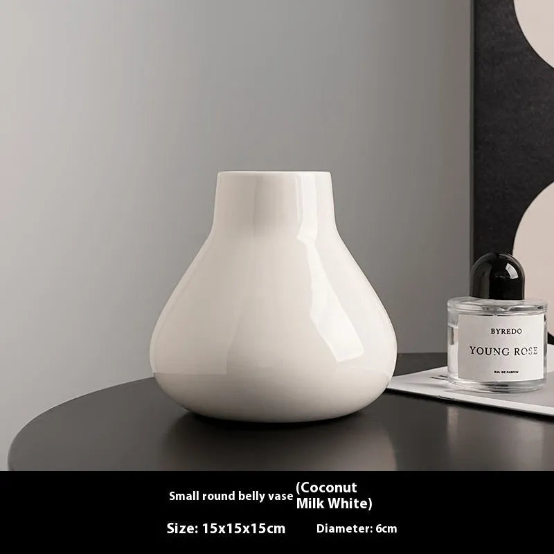Modern ceramic vase with two white artificial orchid stems in minimalist home setting