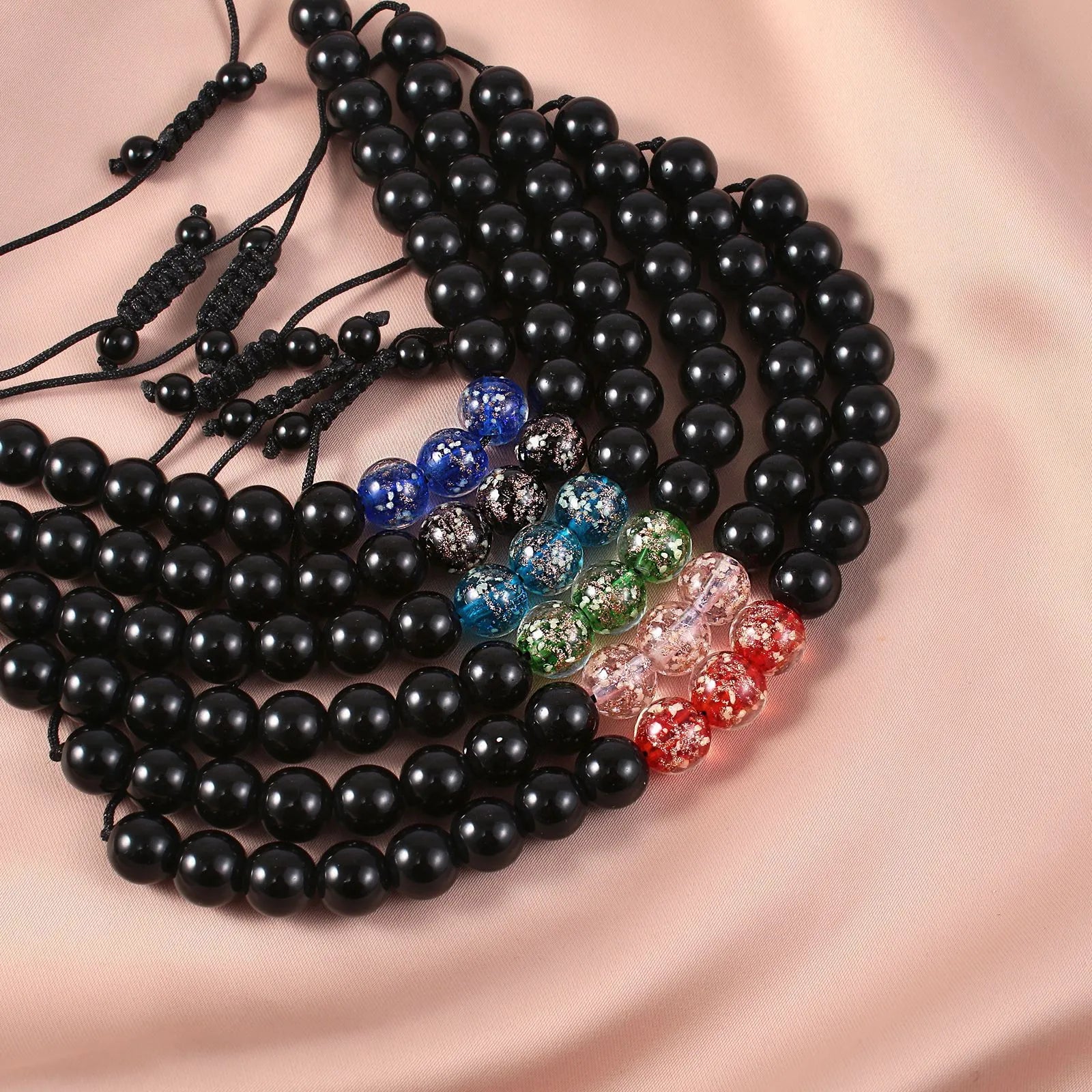 Adjustable luminous glass bead bracelet in geometric shapes on wrist showing elastic cord threading