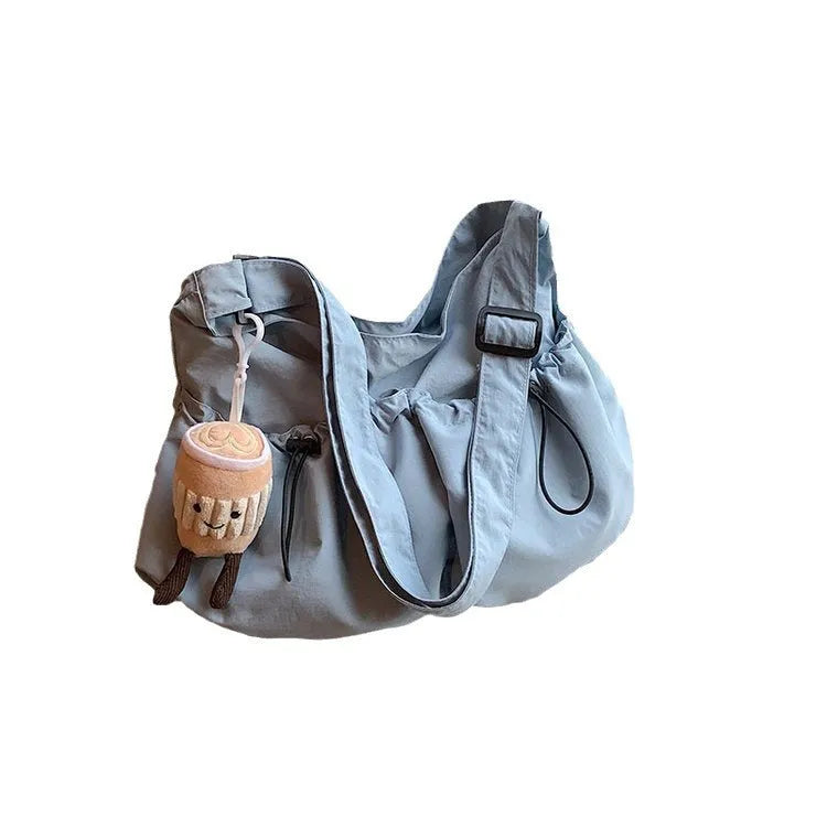 Ultra-light foldable pleated crossbody bag in polyester showing split pockets and mobile phone compartment.