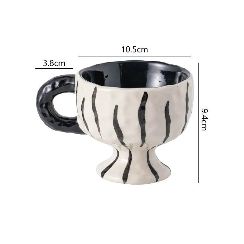 Handmade irregular solid colour ceramic mug on a table, showing its unique shape.