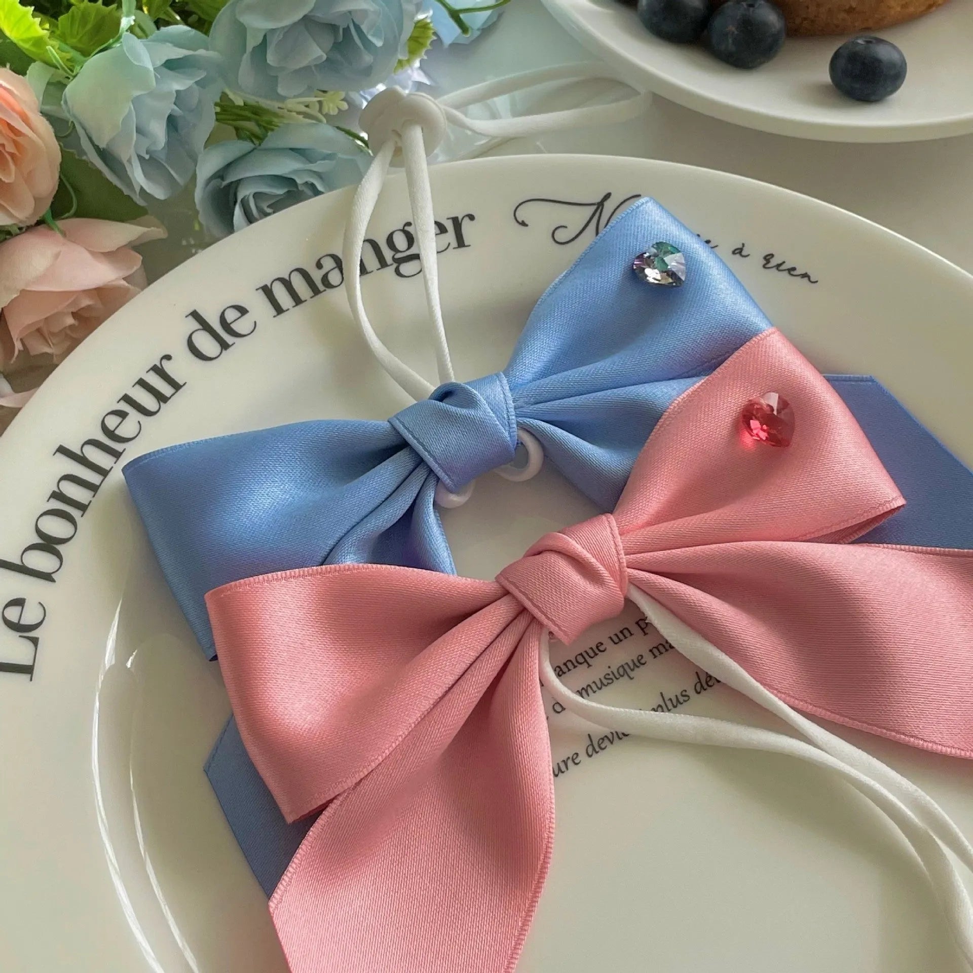 Blue princess bow dog hair band with adjustable tension on a small dog
