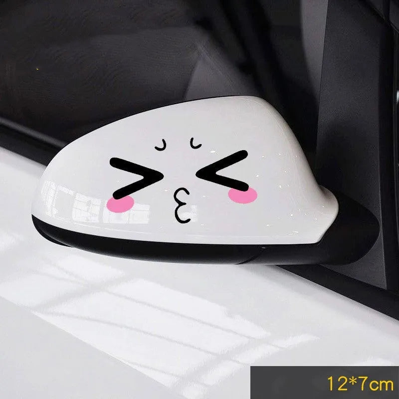 Pair of reflective cartoon car stickers with cute eyes on a car rearview mirror.