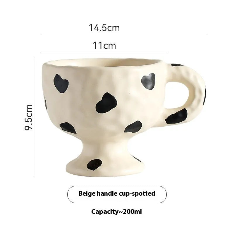 Handmade irregular solid colour ceramic mug on a table, showing its unique shape.