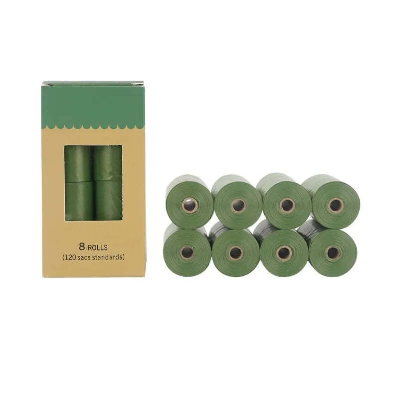 A roll of green EPI degradable pet waste bags next to a black dispenser on a grass background.