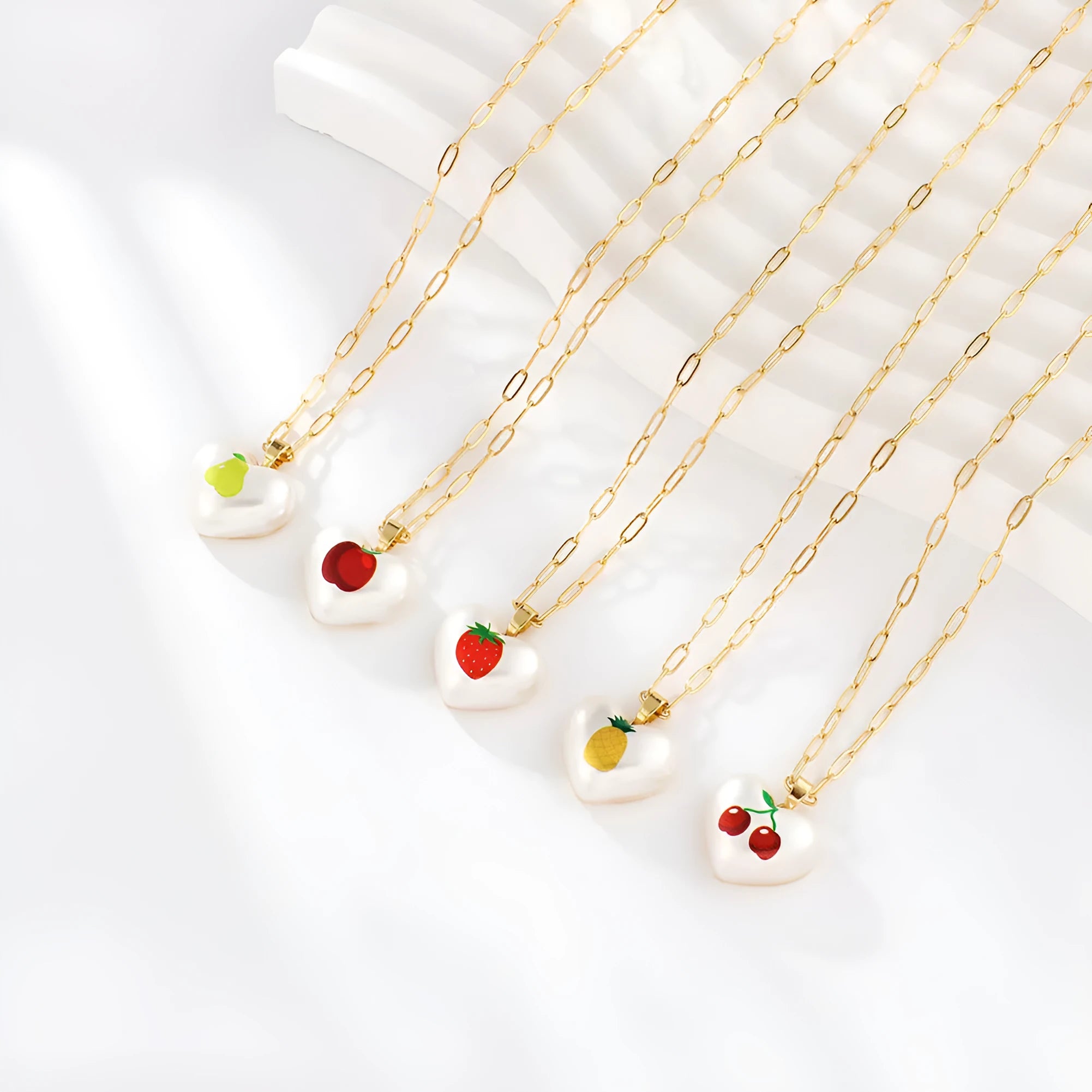 Heart-shaped necklace with fruit pendant on geometric chain showing strawberry pineapple apple pear cherry options