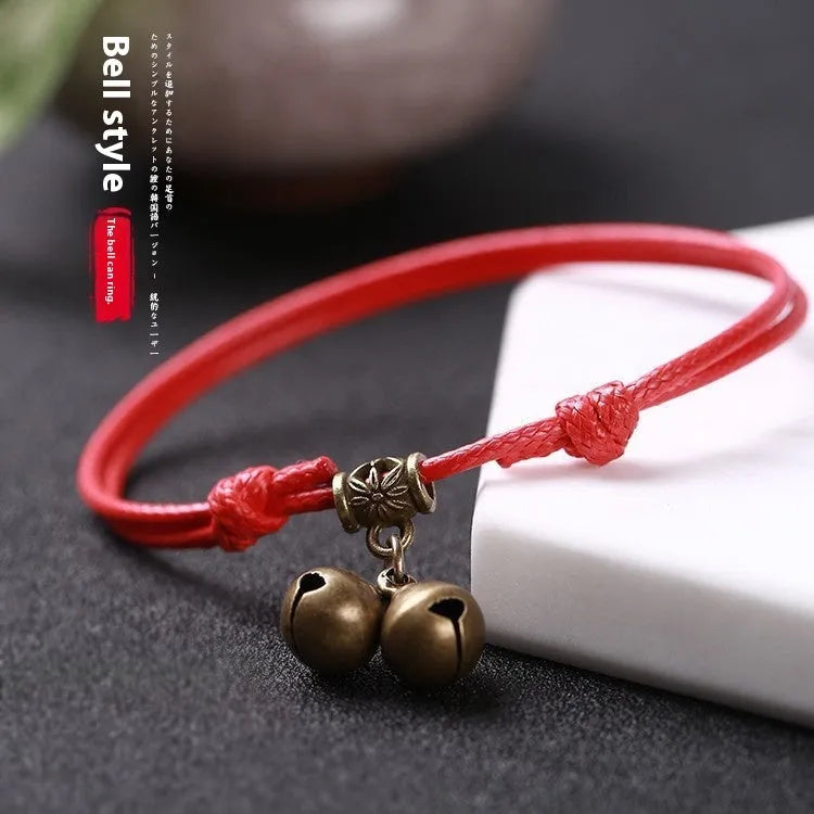 A nylon rope dog collar with a brass buckle shown alongside a version with a brass bell, in black, red, and coffee colours.