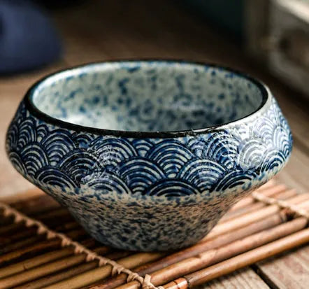 Tall porcelain ceramic Japanese soup bowl with underglaze vintage pattern on wooden table.