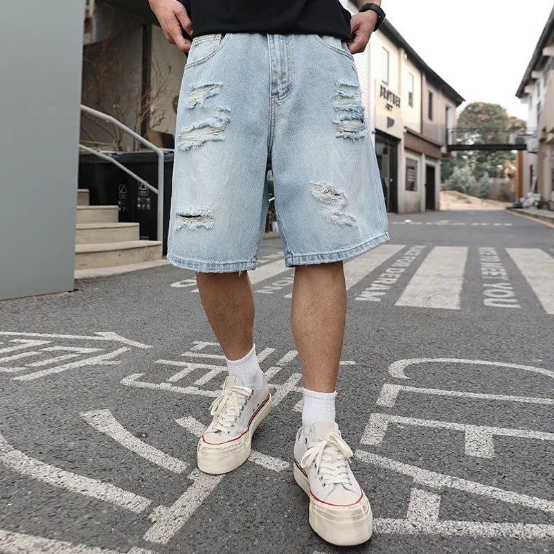 Men's light blue ripped denim shorts with distressed detailing and loose straight cut
