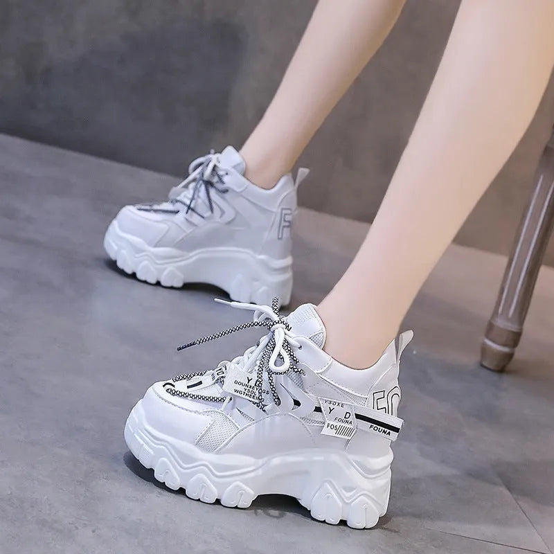 White women's low-top platform sports shoes with a cross-strap and breathable mesh upper on a rubber sole.