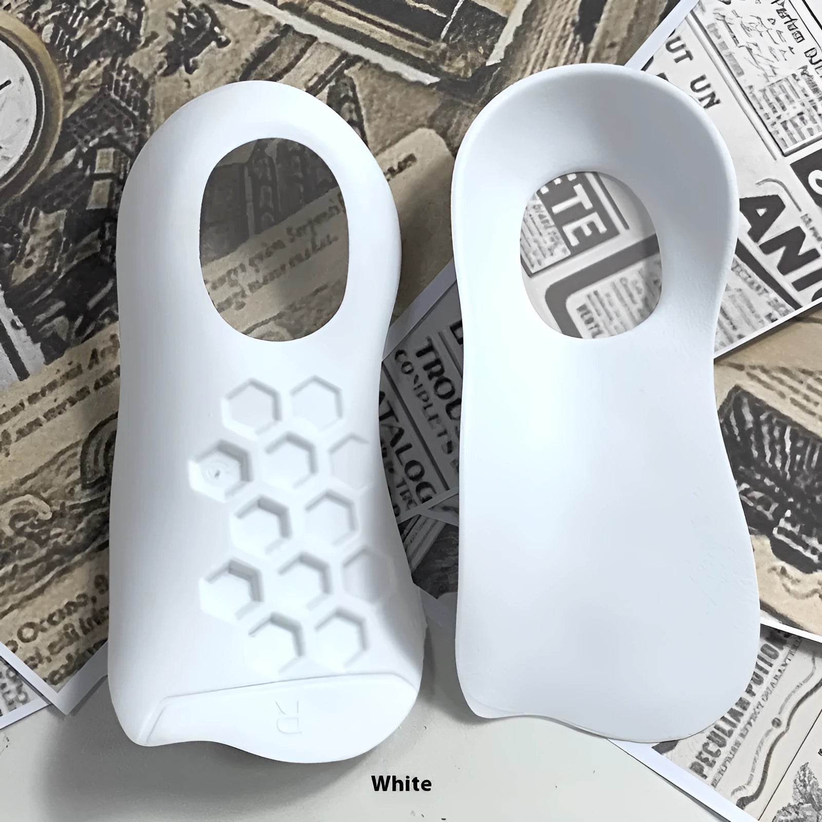 White arch support insole for varus foot correction on a grey background.