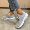 Women's low-top mesh running shoes in creamy white with a Flyknit upper and flat rubber sole.