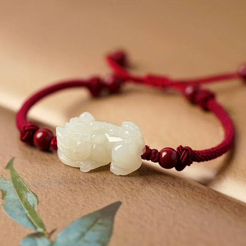 Close-up of a brown and black braided rope bracelet with a central Hetian jade bead on a wrist.