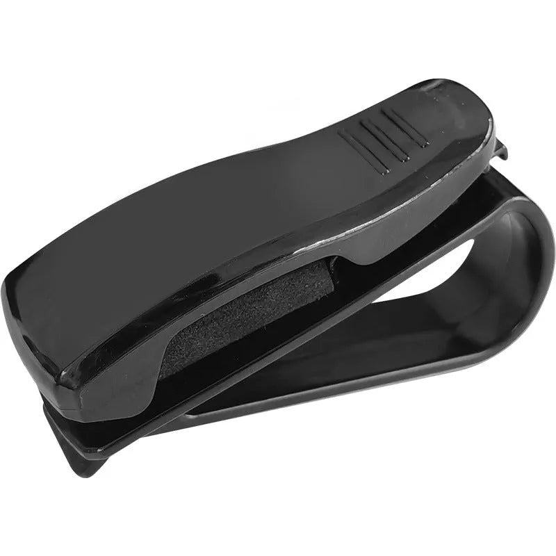 Black plastic multifunctional clip for car sun visors to hold tickets, IDs, or glasses.