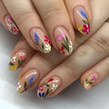 Almond-shaped removable nail art set featuring rose, tulip, and flower patterns on a hand.