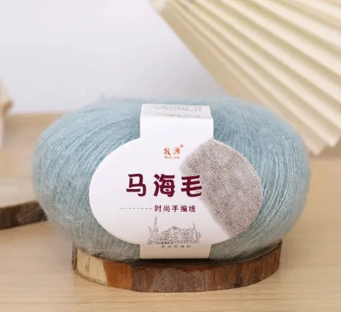Ball of mohair yarn for DIY scarf knitting in one of 34 colours, including white, pink, blue, and green.