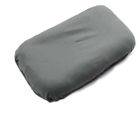 Beige portable baby nest cot crib for infants on a neutral background