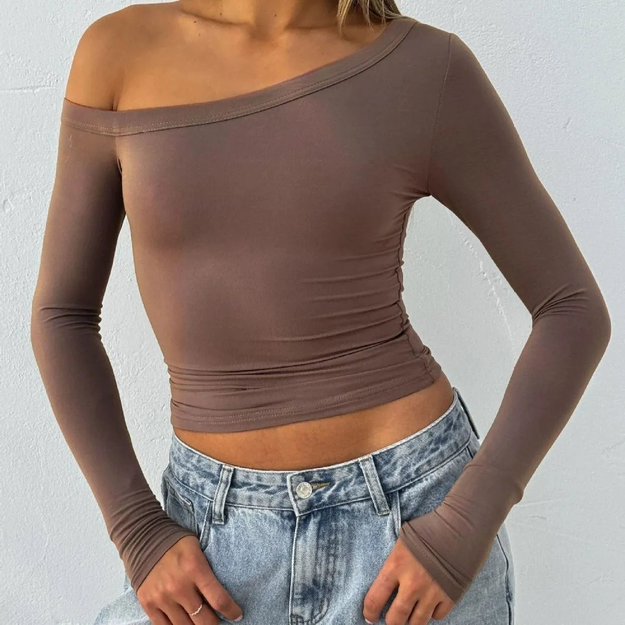 Women's black slim fit knitted cardigan pullover with long sleeves and cross-shoulder strap detail.