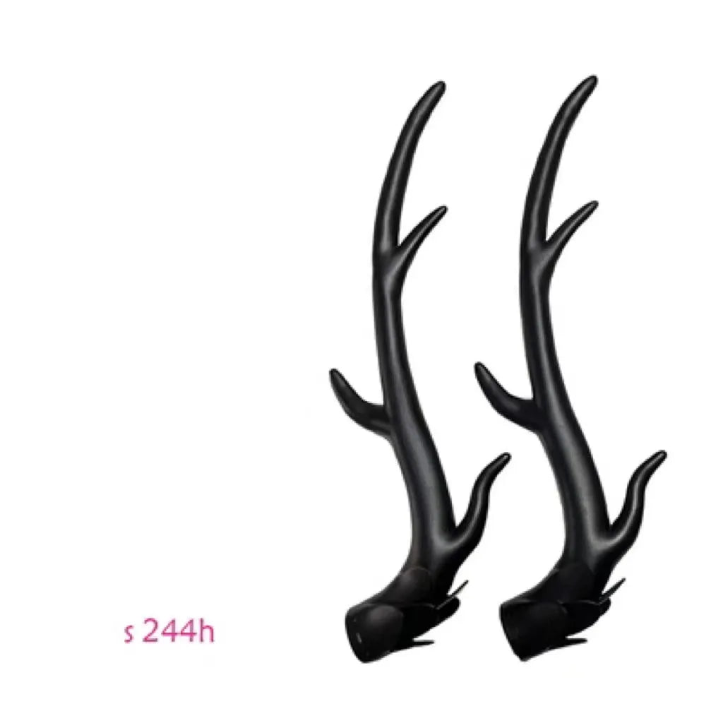 Pair of black resin dragon horn decorations next to a motorcycle helmet, showing scale and detailed texture.