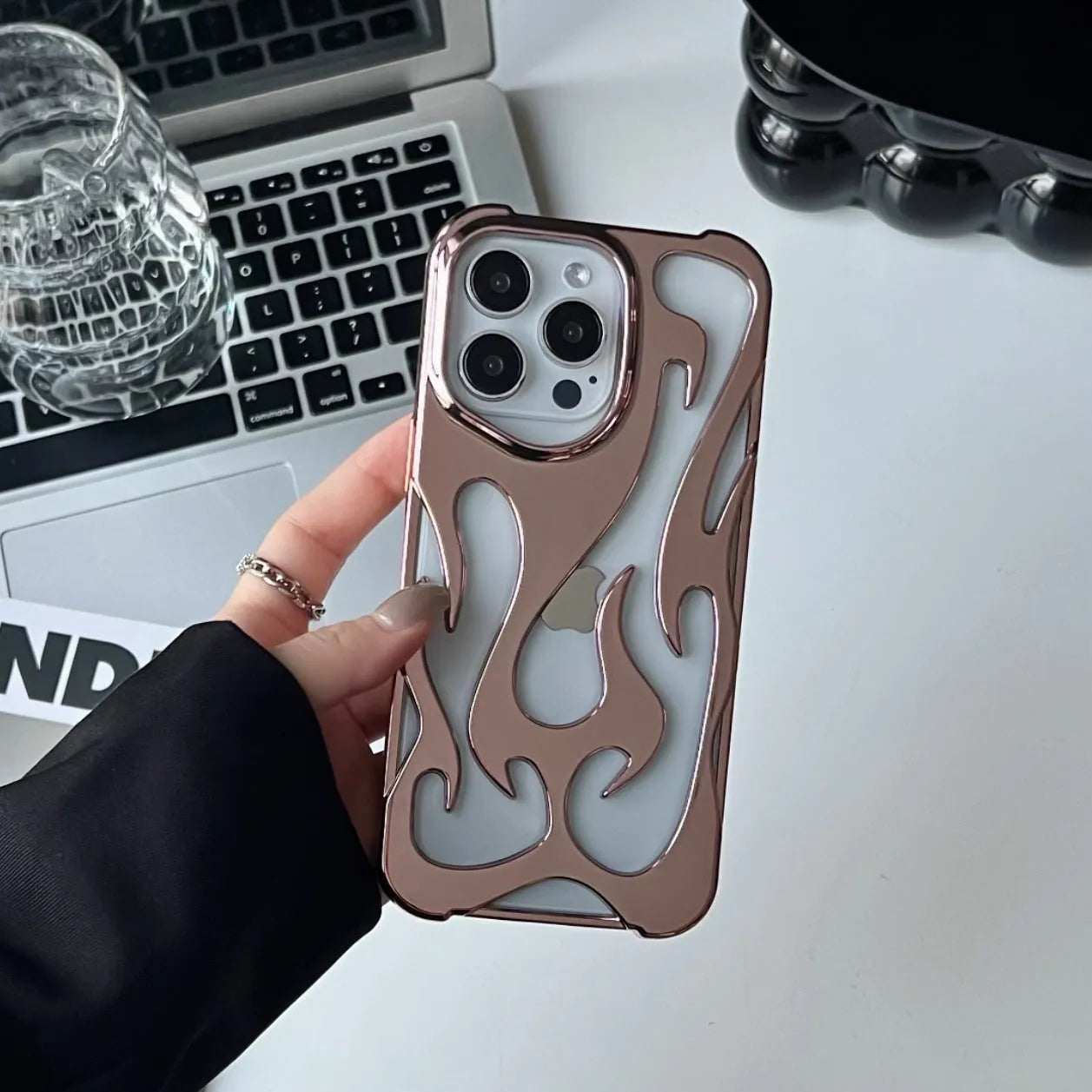Silver electroplated iPhone case with hollow flame pattern design on a dark background