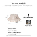 Beige wine bottle-shaped camping lantern with USB-C port and LED light on a wooden surface.