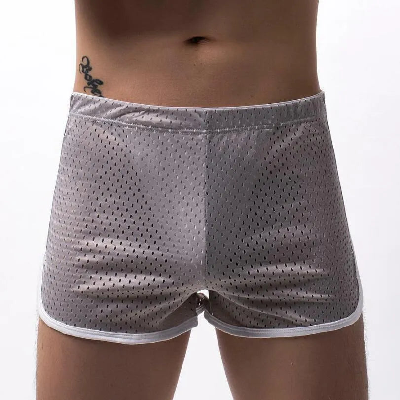 Men's grey cotton blend three-point boxer shorts laid flat, showing mid-waist design and knitted fabric texture.