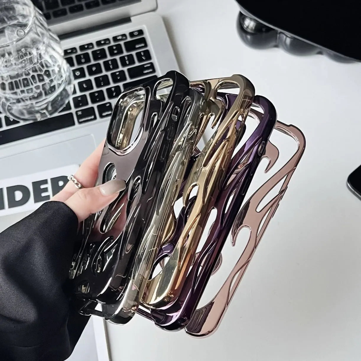Silver electroplated iPhone case with hollow flame pattern design on a dark background
