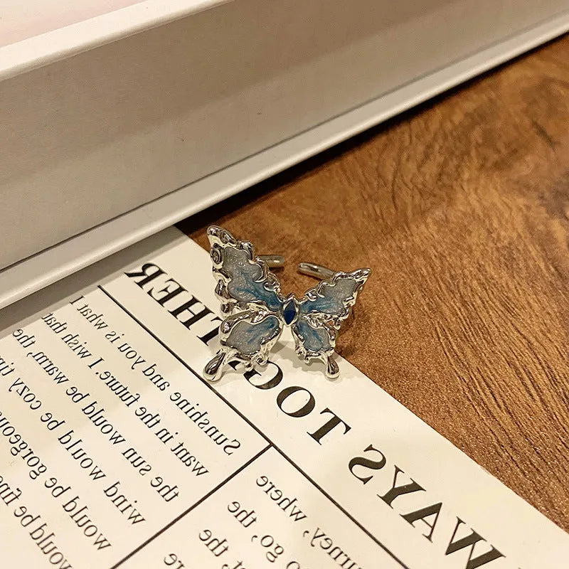 Creative butterfly design women's ring in copper with oil drip finish, showing an open loop style.