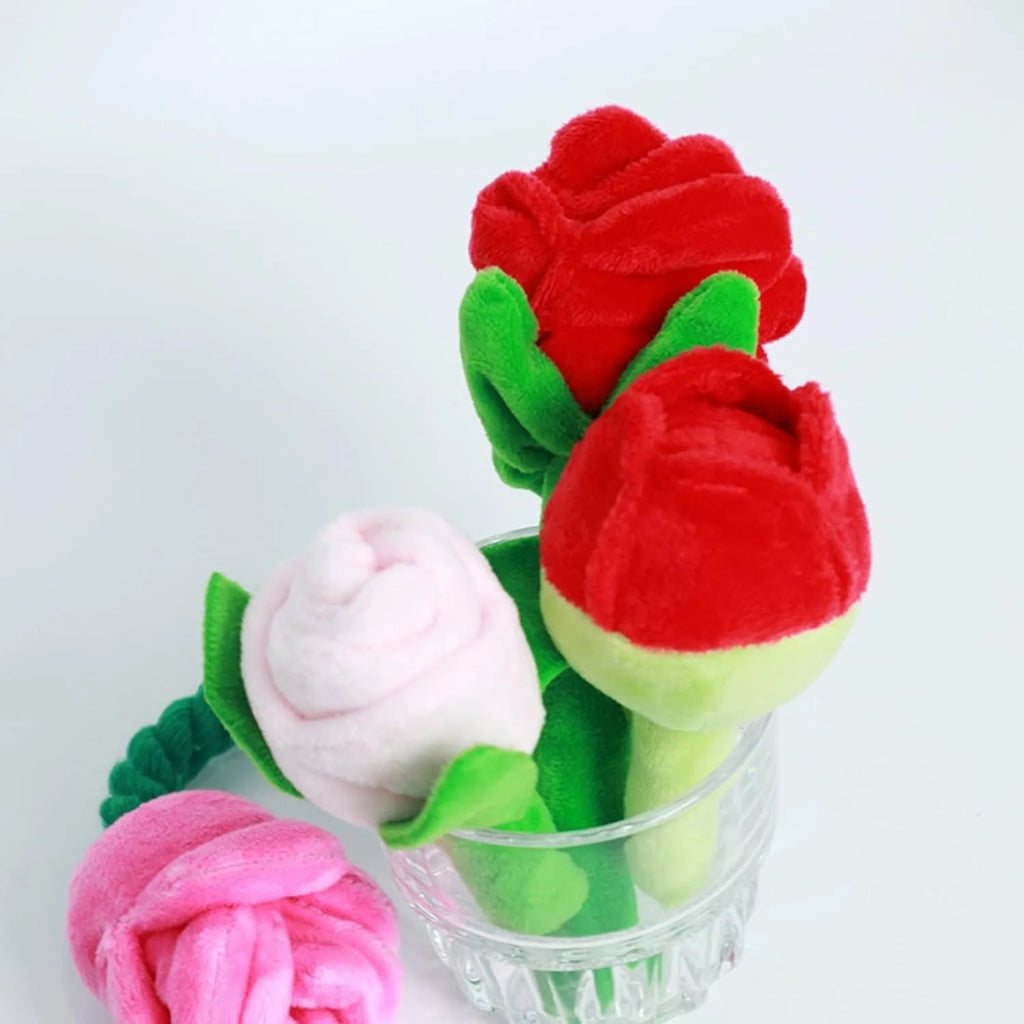 Plush pink rose flower dog chew toy with green leaf and a squeaker inside.