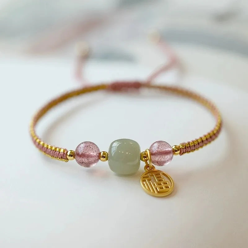 Adjustable red rope bracelet with a choice of Strawberry Quartz or Hetian Jade bead, showing the national style design.