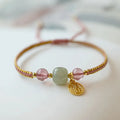 Adjustable red rope bracelet with a choice of Strawberry Quartz or Hetian Jade bead, showing the national style design.