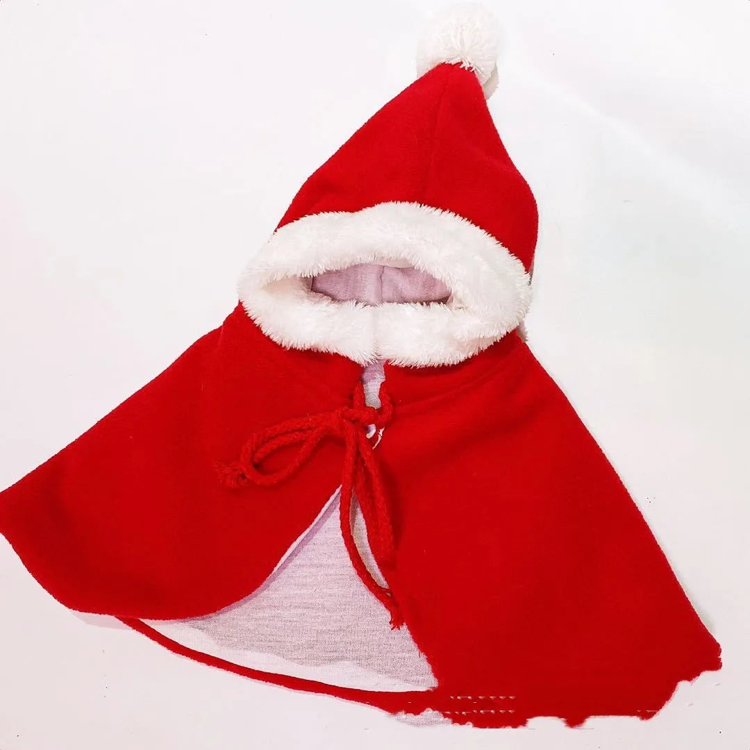 Red Christmas shawl cloak draped on small dog showing cloth fabric and seasonal pet clothing design