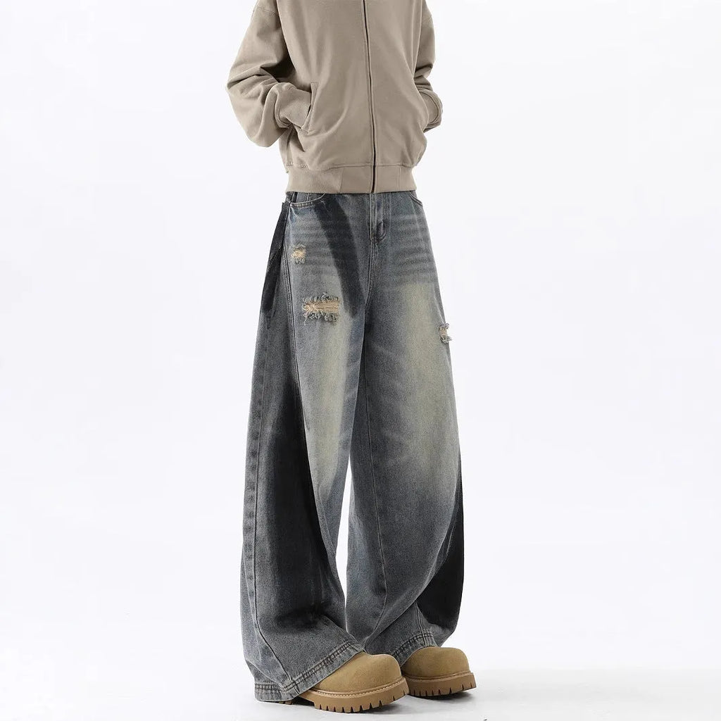 Men's blue ripped jeans with splash-ink design detail showing cotton fabric with micro elasticity