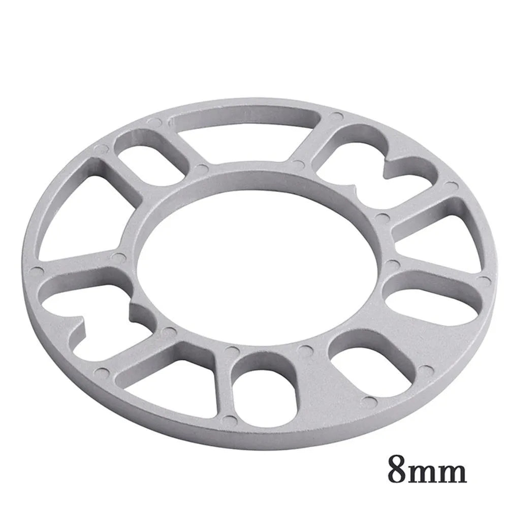 Set of metal hubcentric wheel spacer gaskets in different thicknesses for car brake caliper clearance.