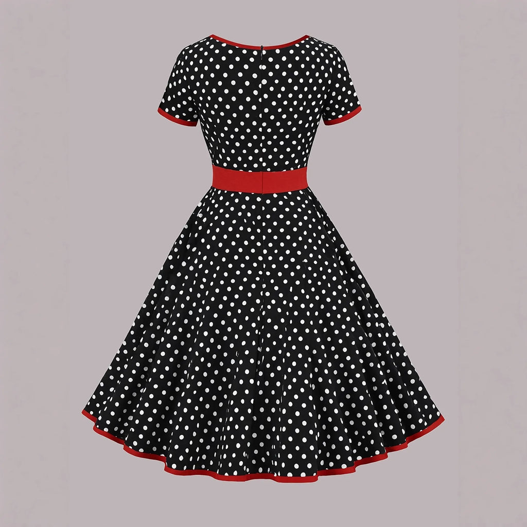 Multicolour polka dot dress with square collar, short sleeves, front zipper, and a pleated mid-length skirt on a hanger.