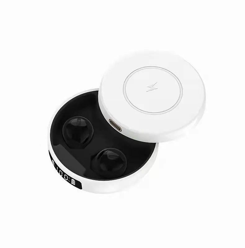 Mini black semi-in-ear wireless headphones with their compact wireless charging case on a table.