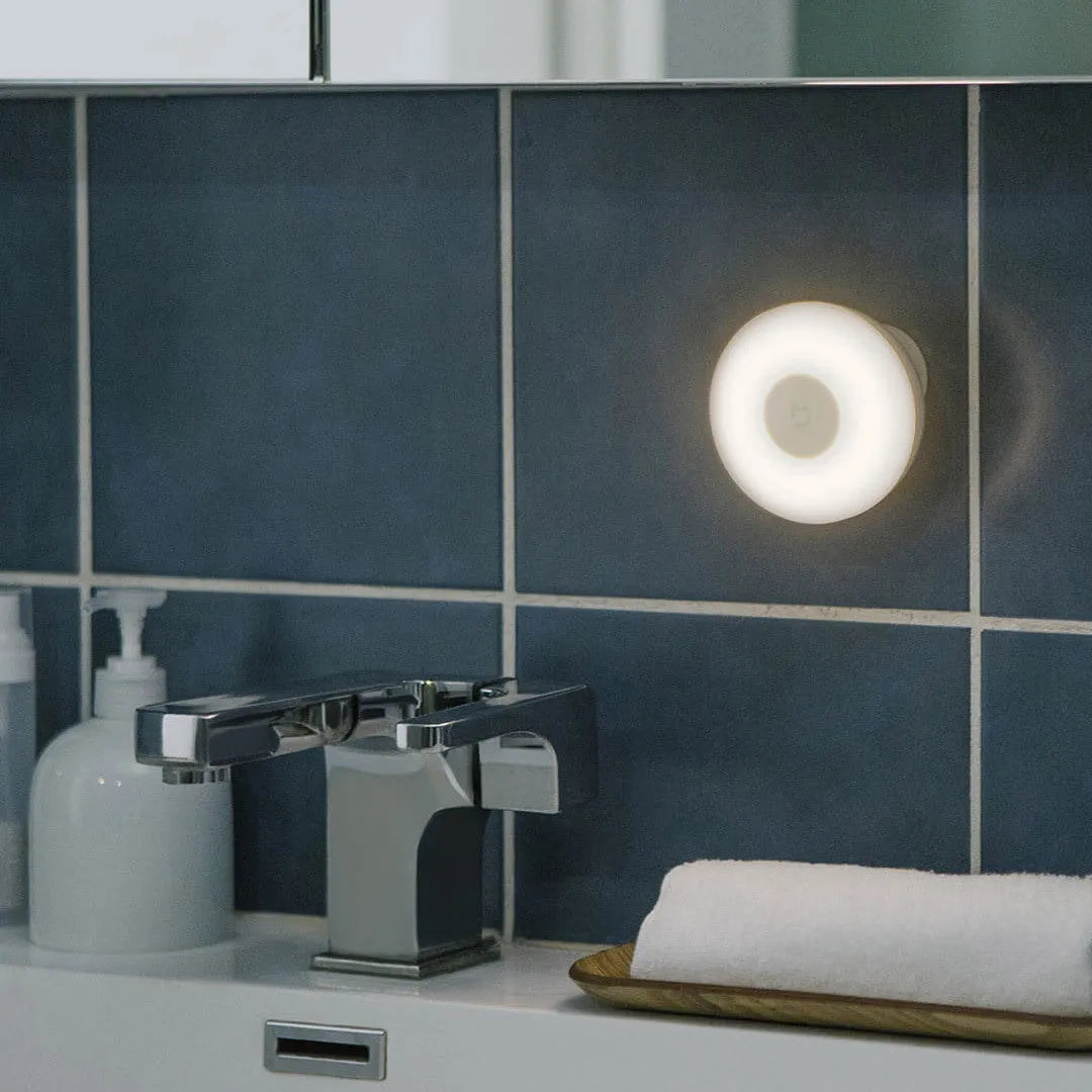 White modern bedside table lamp with human body induction and Bluetooth, shown on a nightstand.
