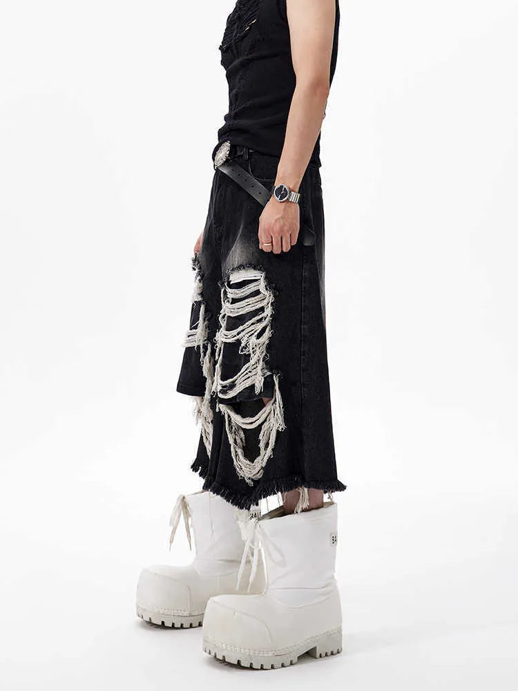 Black wide-leg cropped jeans with a ripped patch detail on the leg, shown on a model.